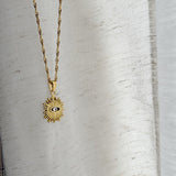 Gold necklace with a sun-shaped eye pendant
